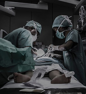 Two doctors performing surgery on a patient